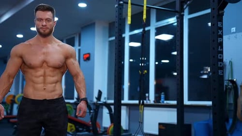 Muscular man posing in gym. Handsome male bodybuilder