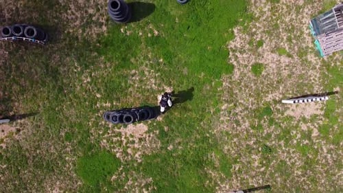 Paintball-Spieler macht einen Stunt und wirft sich auf das Spielfeld, während er ein Paintball-Spiel spielt. Drohne s