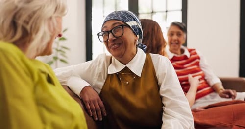 Women Talking and Laughing Together on Sofa