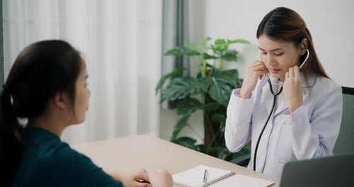 Friendly Doctor Examining Patient with Stethoscope