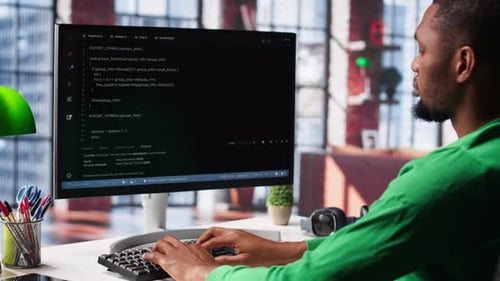 Man Typing Code at Computer Workstation