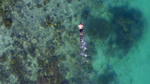 Images d'un Drone 4K montrant un homme faisant de la plongée avec tuba dans l'océan indonésien