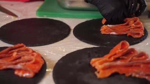 Preparing Raw Salmon Slices on Plates for Catering