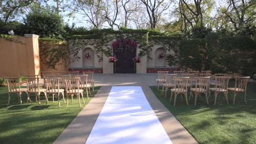 Cozy Green Courtyard with Decorations and Flowers Rows of Chairs White Path