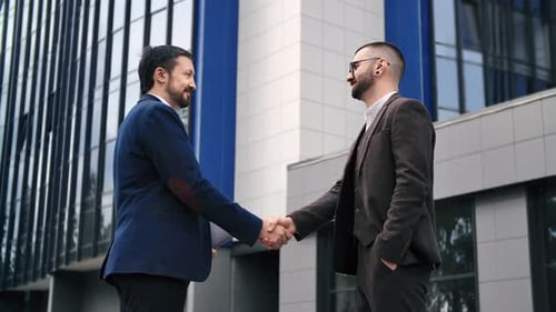 Two Smiling Fashion Business Man Handshaking Greeting to Each Other at Informal Meeting Outdoor