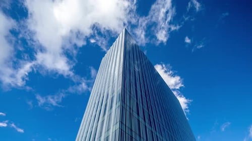 Glass Office Building in Barcelona with Passing Clouds