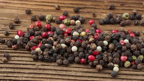 Mixed Peppercorns on Rustic Wooden Surface