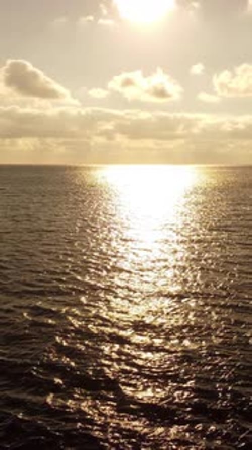 Sea Water Surface at Sunset Vertical Aerial View Camera Flies Over Calm Golden Sea Sun Glare