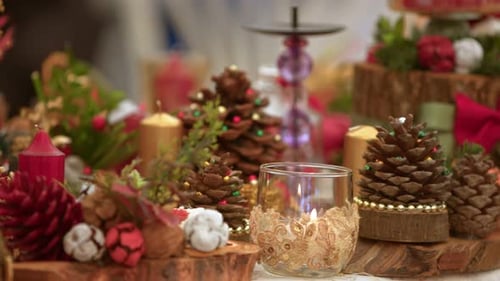 Süße Weihnachtsdekoration mit Tannenzapfen-Ornamenten und Kerzenlicht 1