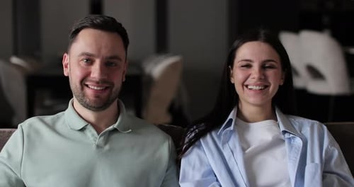 Smiling Couple Sitting on Couch Indoors