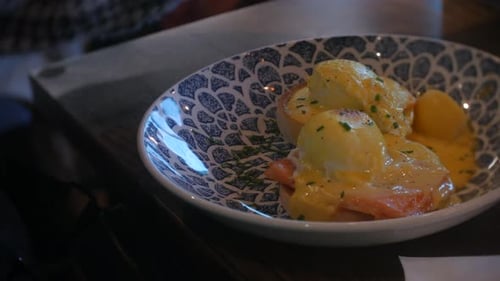 Eggs Benedict plated with hollandaise sauce and chives