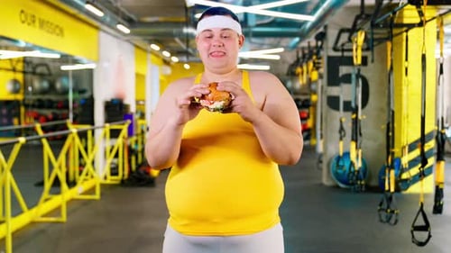 Man in Gym Holding Burger