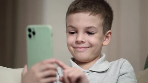 Happy Boy Using Smartphone Indoors