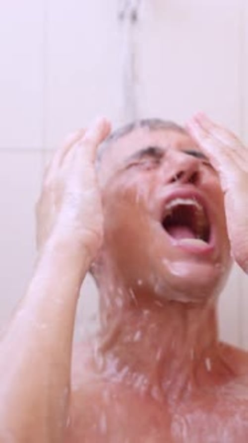 Young Man Washing Hair and Face in Shower