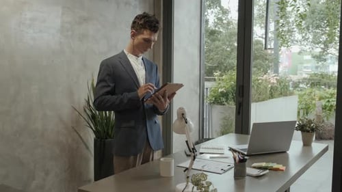 Young Businessman with Tablet Working in the Internet in Office