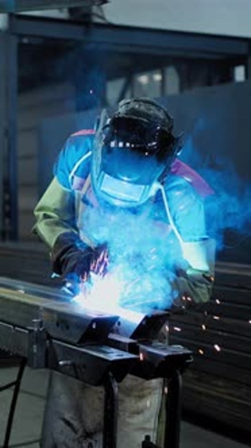 Expert Welder Working on Metal Fabrication in Workshop with Sparks Flying
