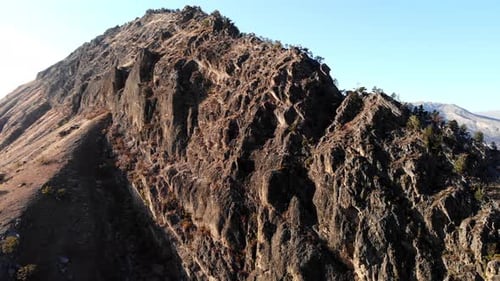 Jagged Peaks Against Clear Blue Sky Vast Valley With Rugged Rocky Slopes Beneath Bright Daylight