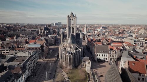Panoramic aerial view of Sint-Niklaaskerk tower over Ghent rooftops Belgium