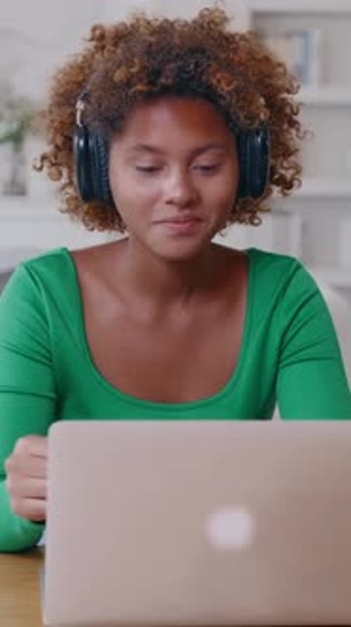 Young Woman Video Calling with Laptop and Headphones