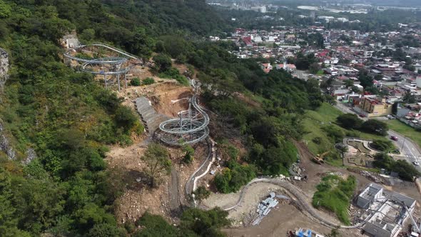 Steel Roller Coaster Construction Site On A Hillside With Vegetation In steel-roller-coaster-construction-site-on-a-hillside-with-vegetation-in