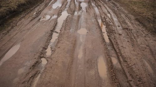 Kaputter Feldweg mit einem Sumpf