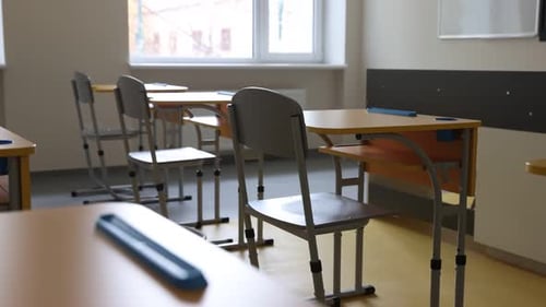 Stylish classroom with desks and chairs at school. Camera moving left