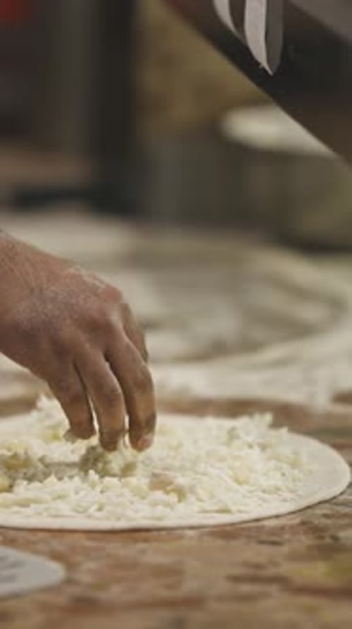 The Chef Sprinkles the Cheese on the Pizza Dough Before