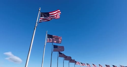 American Flags Waving Against Blue Sky