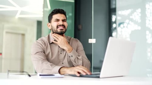 Man at Desk Typing with Sore Throat