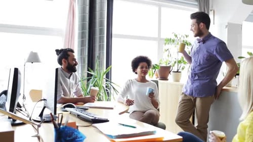 Happy multiethnic business team drinking coffee during break at the office