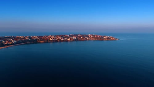 Multiple houses located on the spit surrounded by the beautiful dark blue waterscape.