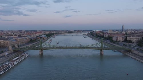 Os atacantes voam acima do amplo rio Danúbio e suas pontes. Vista panorâmica dos bairros urbanos ao longo do rio em