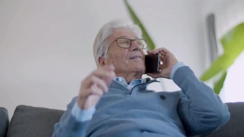 Senior Man Talking on Phone on Couch