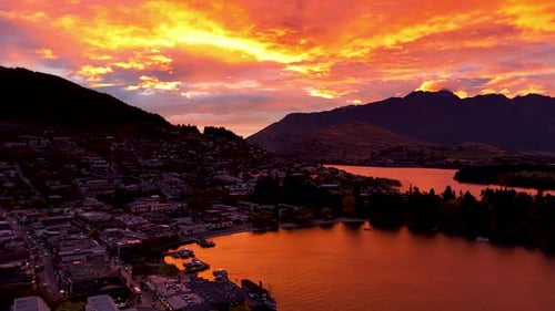 Aerial view at an orange sunrise over Queenstown on the shores of Lake Wakatipu and the Southern Alp