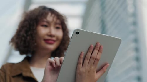 Woman Using Tablet Device in Urban Setting