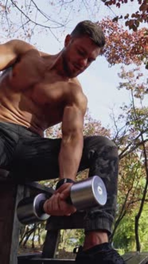 Muscular Man Lifting Weights Outdoors in the Fall