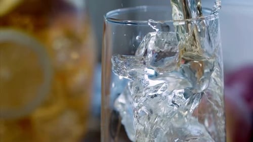 Refreshing Drink Being Poured Into Glass of Ice