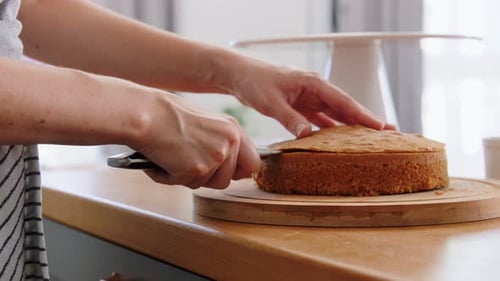 Woman cuts a cake layer for decorating cake