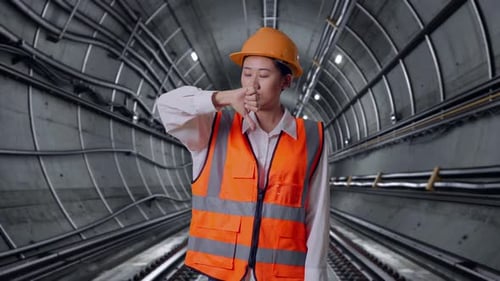 Asian Female Engineer Showing Thumbs Down Gesture And Shaking Her Head In Subway Tunnel