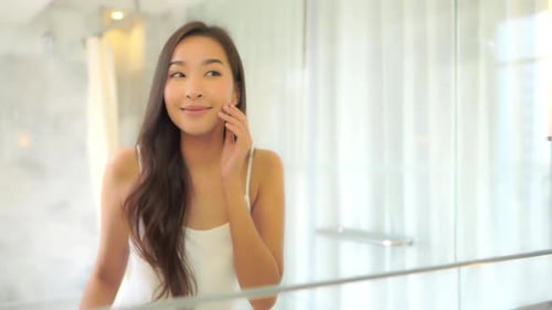 Young Woman Smiling in Bathroom Mirror