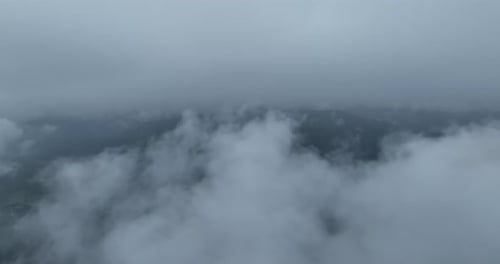 Aerial View of Clouds Rolling Over Mountains