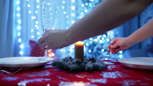 Female Hands Put Two Champagne Glasses on the New Year's Table