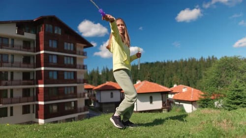 Girl in Bright Suit Plays Outdoors and Blows Soap Bubbles on Sunny Meadow in Backyard