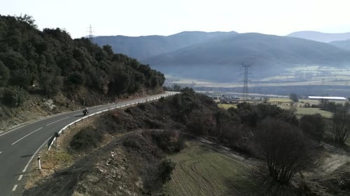 A Biker Crossing a Road in the Wilderness