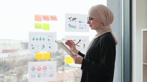Young Woman Reviews Data in Modern Office