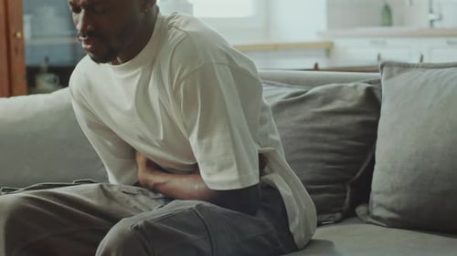 African American Man Suffering from Stomach Pain at Home