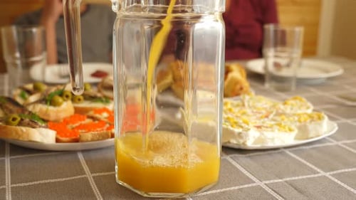 Pouring Fresh Orange Juice for Delicious Brunch