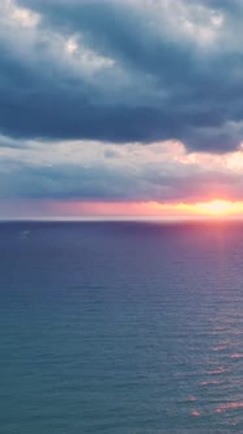 Vertical Video Scenic Sunset Over the Ocean With Stunning Colors Illuminating the Sky and Reflecting