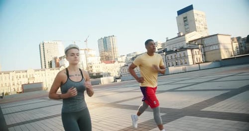 Athletic Man and Woman Jogging in Urban Setting