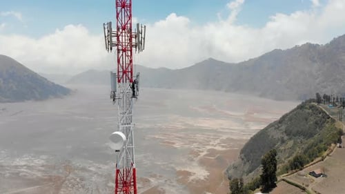 Aerial view of man climbing tower in mountains, Indonesia.